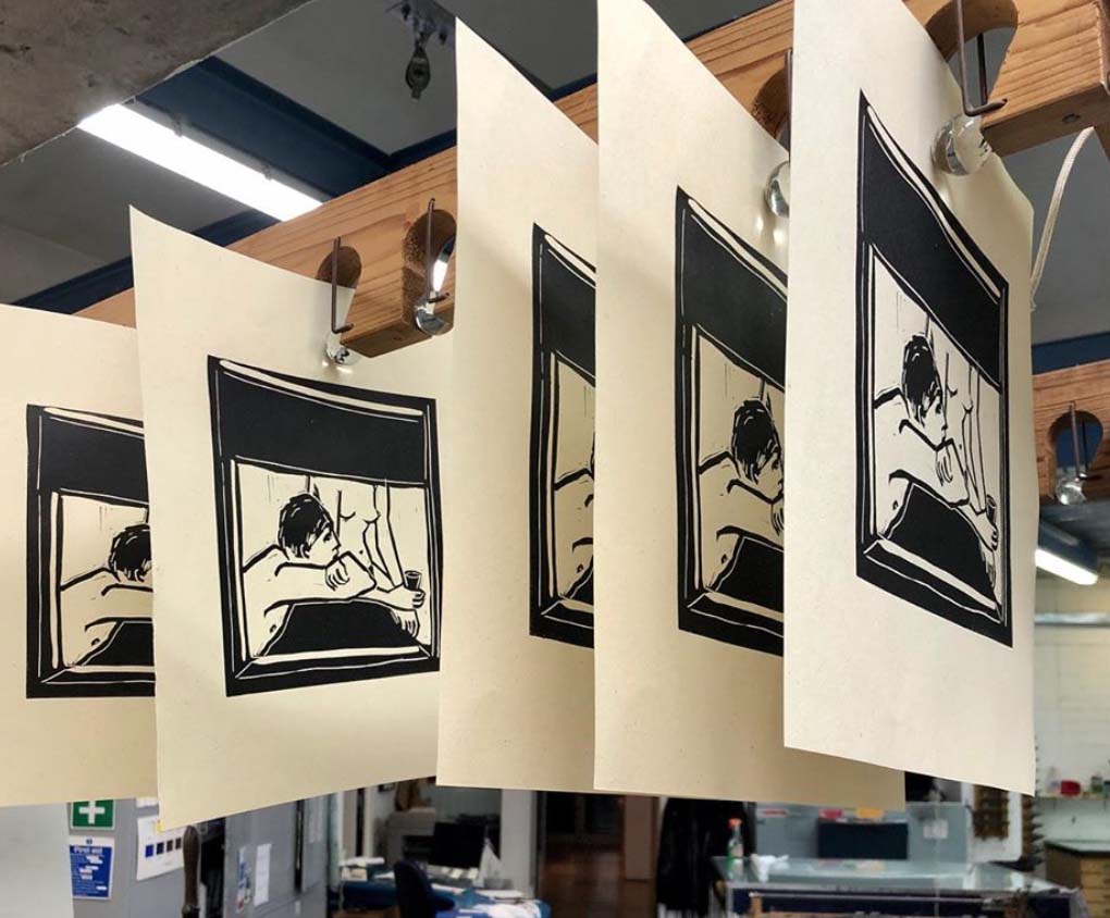 linocuts on paper hanging in a drying rack